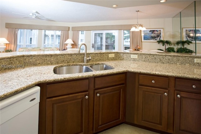 kitchen with a healthy amount of sunlight, sink, light stone counters, and dishwasher