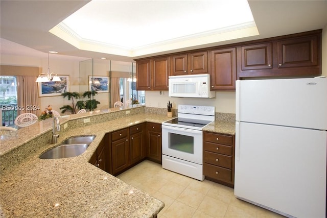 kitchen featuring sink, white appliances, kitchen peninsula, decorative light fixtures, and a raised ceiling