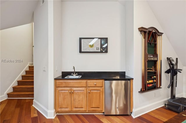 bar with fridge, dark hardwood / wood-style floors, sink, and vaulted ceiling