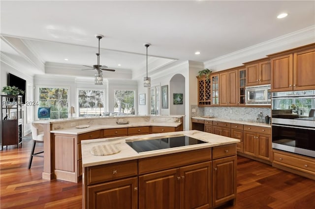 kitchen featuring stainless steel appliances, a kitchen island, pendant lighting, and a kitchen breakfast bar