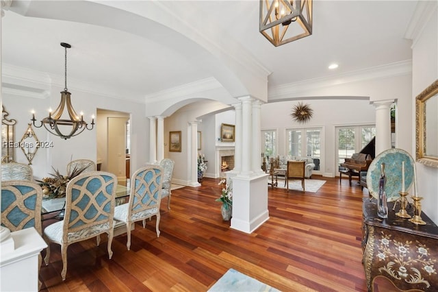 dining room featuring ornamental molding, dark wood-type flooring, and decorative columns