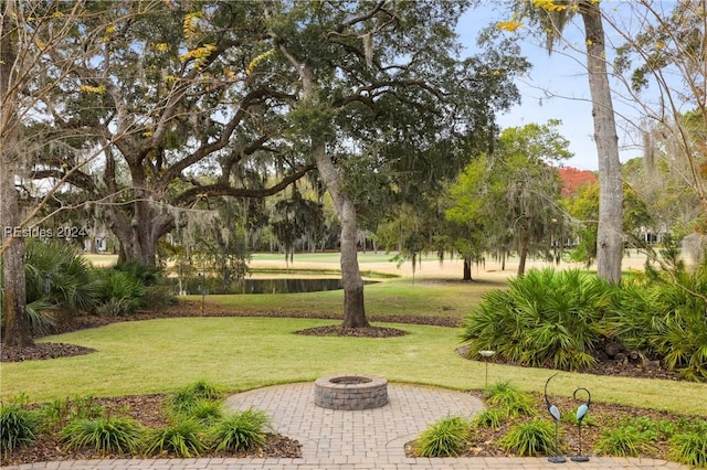 view of home's community with an outdoor fire pit and a yard