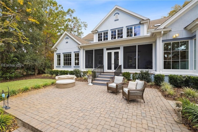 back of house with an outdoor hangout area, a patio area, a sunroom, and a lawn