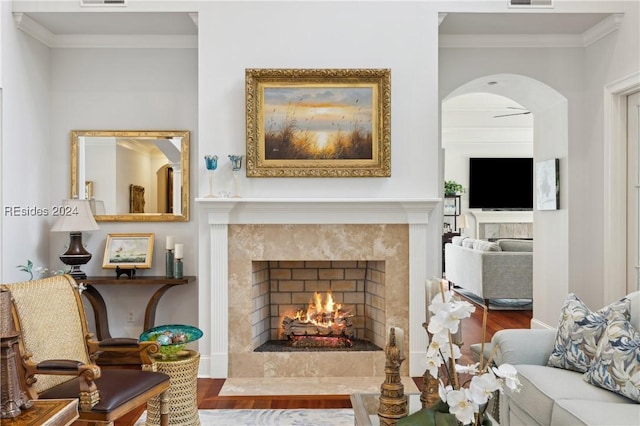 living room with hardwood / wood-style floors, a high end fireplace, and ornamental molding