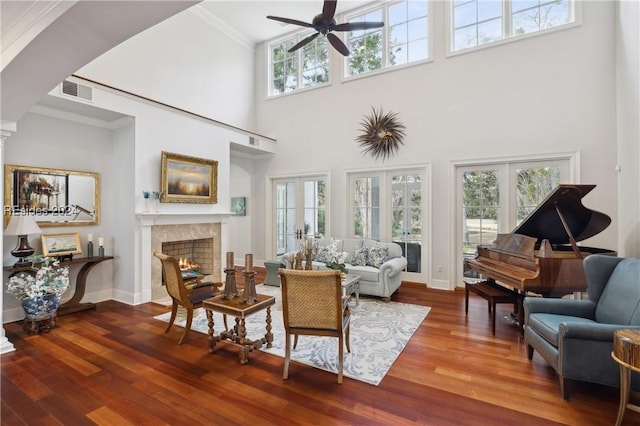 living room featuring hardwood / wood-style floors, ornamental molding, french doors, and a high ceiling