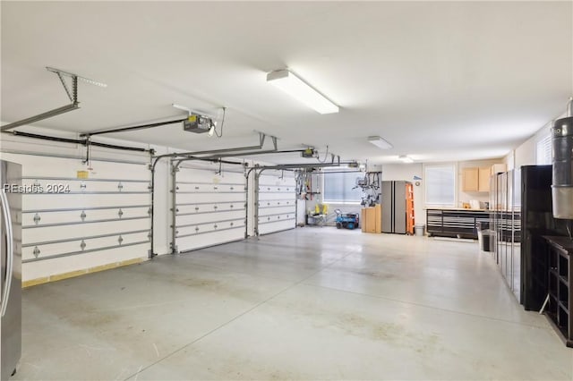 garage featuring stainless steel refrigerator and a garage door opener