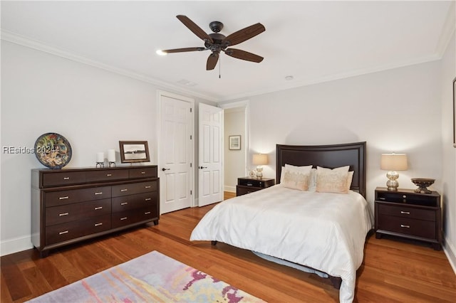 bedroom featuring hardwood / wood-style flooring, ornamental molding, and ceiling fan