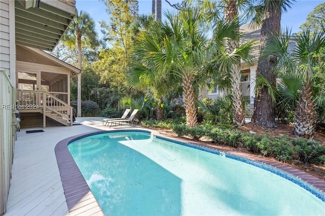 view of swimming pool with a patio area and a sunroom