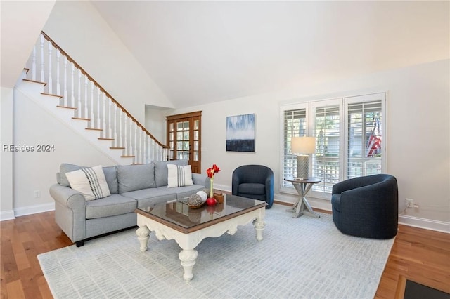 living room featuring french doors, wood-type flooring, and high vaulted ceiling