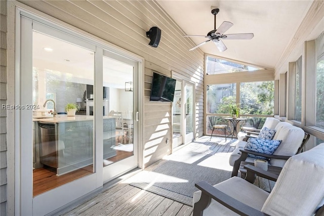 sunroom with lofted ceiling, plenty of natural light, sink, and ceiling fan