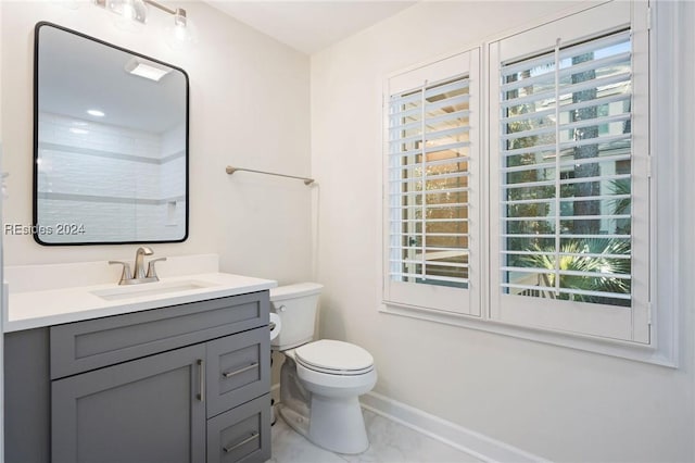 bathroom with vanity, a wealth of natural light, and toilet