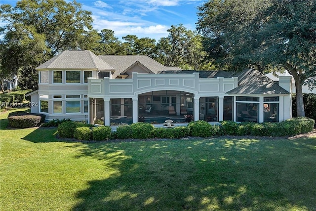 back of property with a sunroom and a lawn