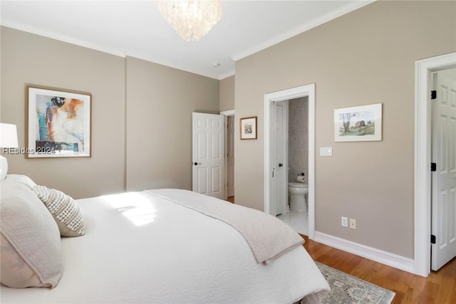 bedroom with an inviting chandelier, ensuite bathroom, crown molding, and light hardwood / wood-style flooring