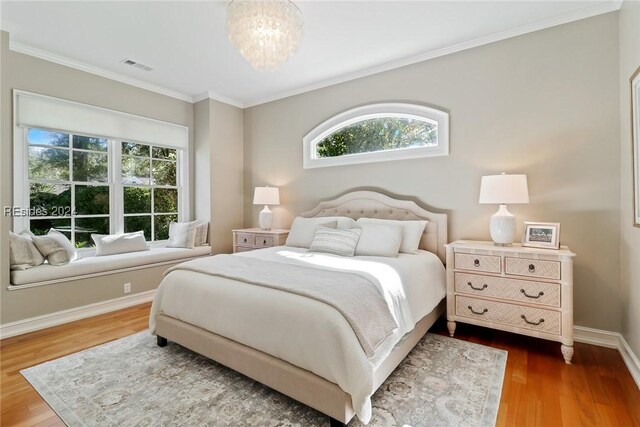 bedroom featuring multiple windows, crown molding, dark wood-type flooring, and a chandelier