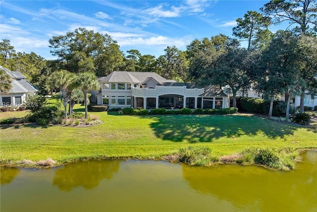 exterior space with a balcony, a water view, and a yard