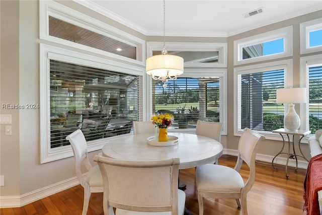 dining area featuring wood-type flooring, ornamental molding, and plenty of natural light