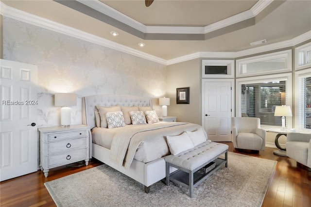 bedroom with a raised ceiling, crown molding, and dark wood-type flooring