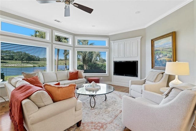 living room with hardwood / wood-style flooring, ornamental molding, and ceiling fan