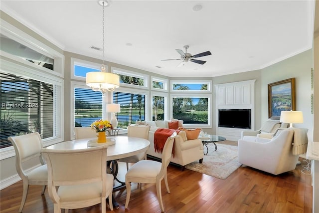 living room featuring dark hardwood / wood-style flooring, ceiling fan with notable chandelier, and ornamental molding