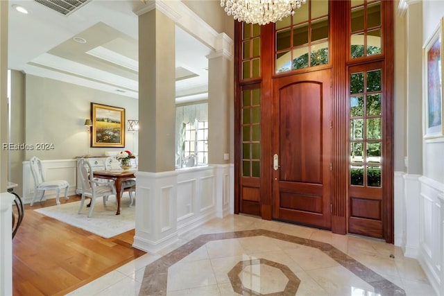 entrance foyer featuring an inviting chandelier and crown molding