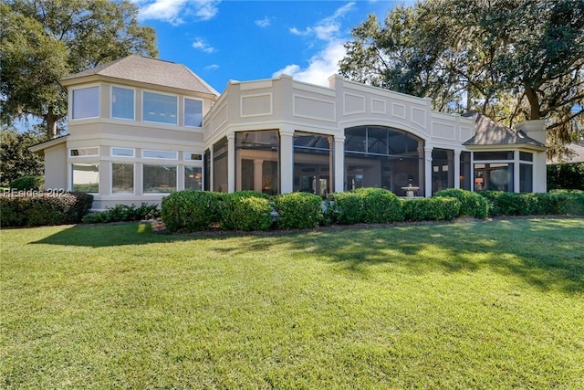 rear view of property with a yard and a sunroom