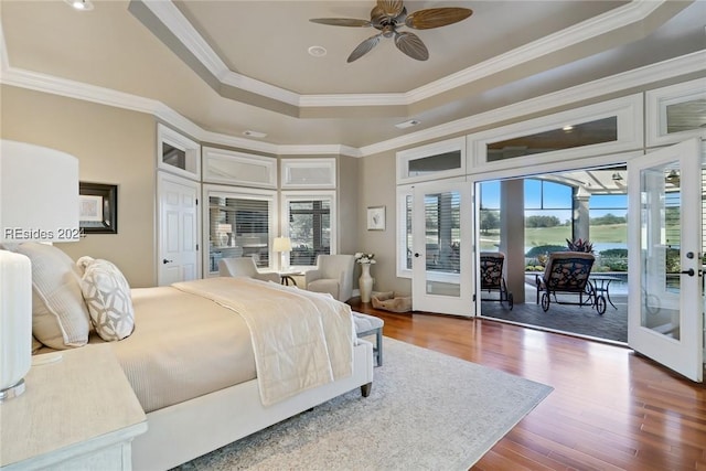 bedroom featuring a raised ceiling, ornamental molding, access to exterior, and french doors