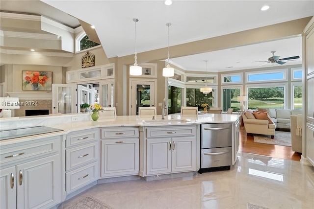 kitchen featuring sink, pendant lighting, white cabinets, and light stone counters