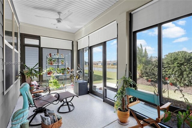 sunroom with a water view and ceiling fan