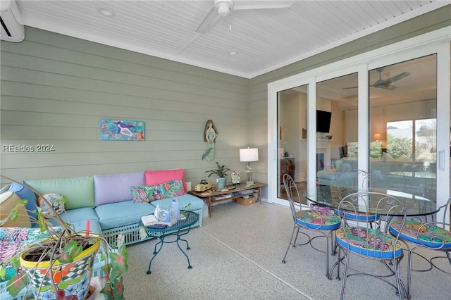 sunroom / solarium featuring ceiling fan, a fireplace, and a wall mounted AC