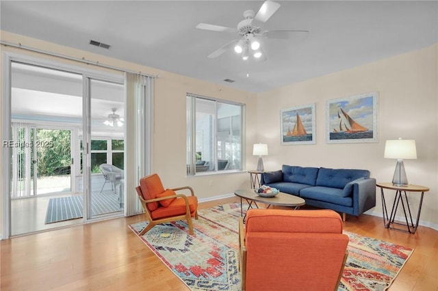 living room with ceiling fan and light wood-type flooring