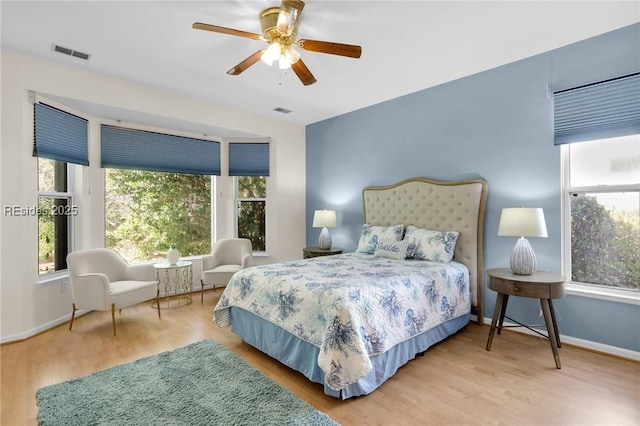 bedroom with hardwood / wood-style flooring, ceiling fan, and multiple windows