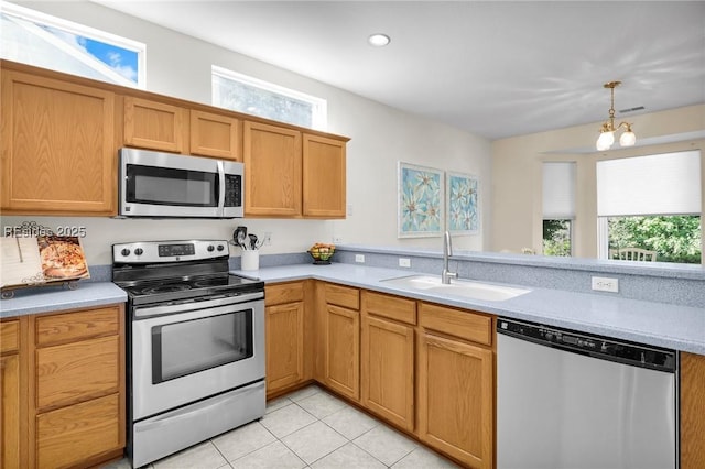 kitchen with plenty of natural light, stainless steel appliances, sink, and light tile patterned floors