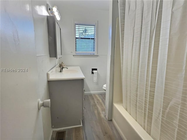 full bathroom featuring shower / bathtub combination with curtain, vanity, toilet, and hardwood / wood-style floors