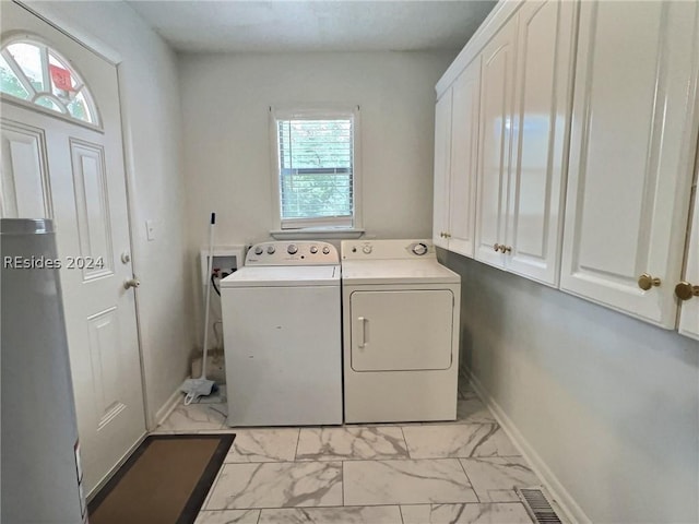 laundry room featuring cabinets and washing machine and clothes dryer