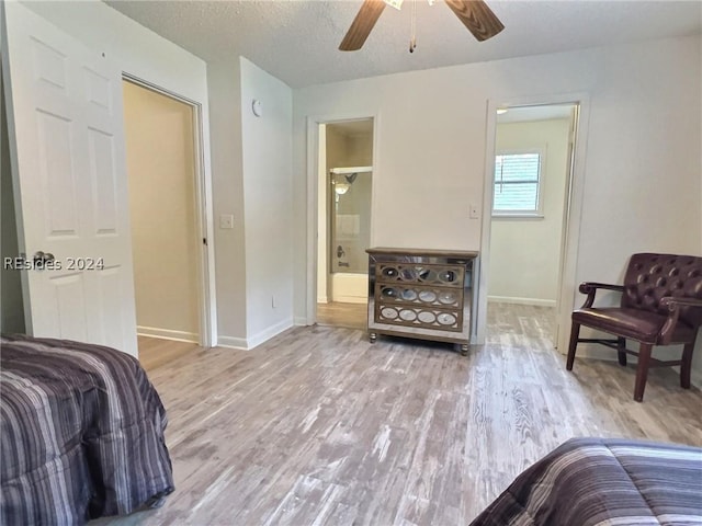 bedroom with hardwood / wood-style floors, a textured ceiling, ceiling fan, and ensuite bathroom