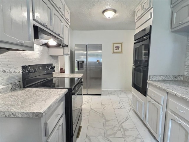 kitchen featuring gray cabinetry, backsplash, black appliances, and a textured ceiling