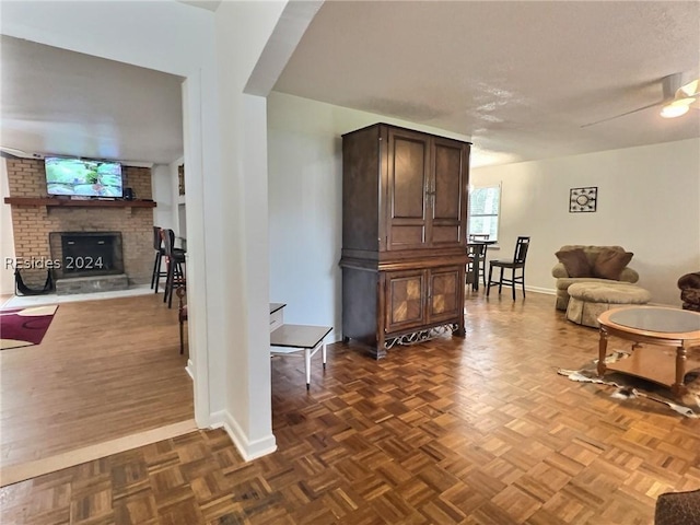 living room with dark parquet flooring and a brick fireplace