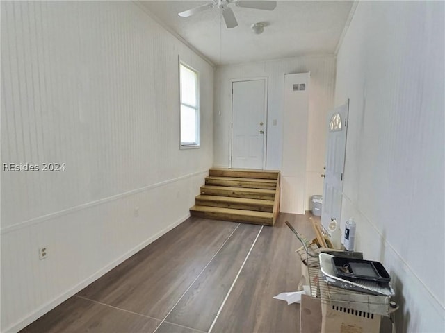 spare room with crown molding, ceiling fan, and dark wood-type flooring