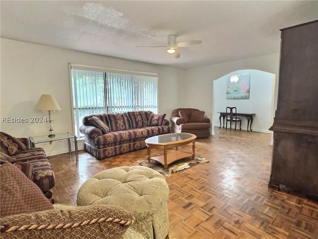 living room with ceiling fan, parquet flooring, and a textured ceiling