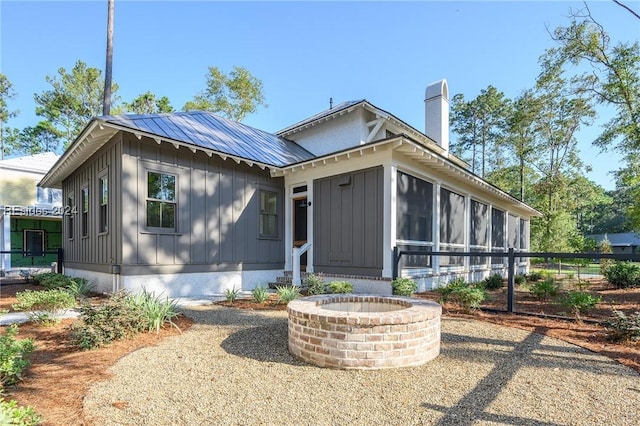 view of front of house featuring a sunroom and a fire pit