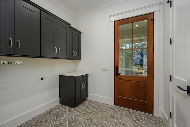 laundry area with cabinets, ornamental molding, and hookup for an electric dryer