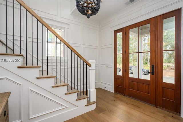 entryway with plenty of natural light, a chandelier, and light hardwood / wood-style floors