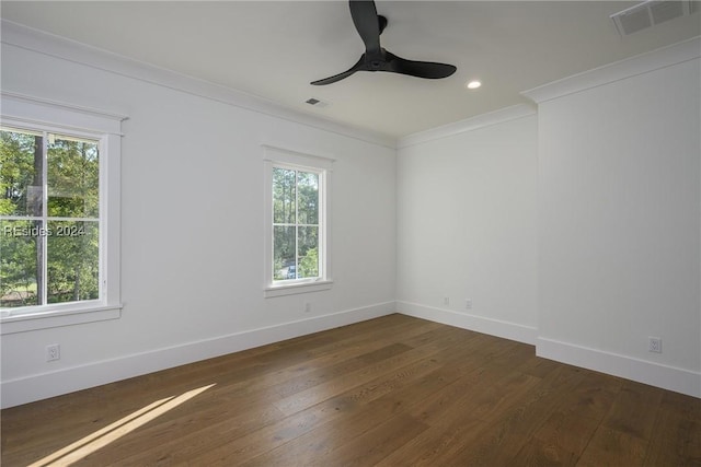 spare room with crown molding, plenty of natural light, dark wood-type flooring, and ceiling fan