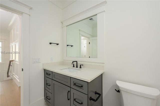 bathroom with hardwood / wood-style flooring, vanity, and toilet