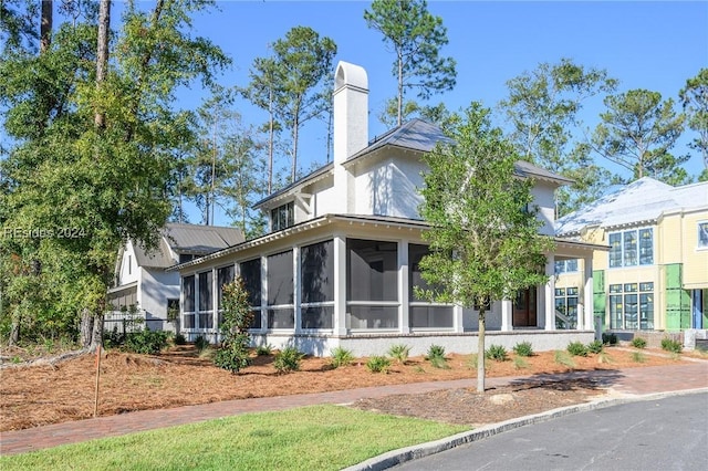 view of property exterior featuring a sunroom