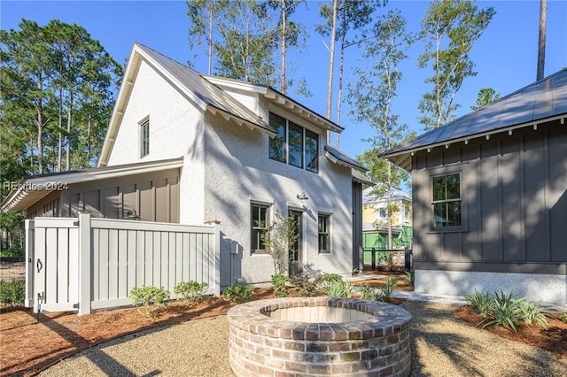 back of house with a fire pit