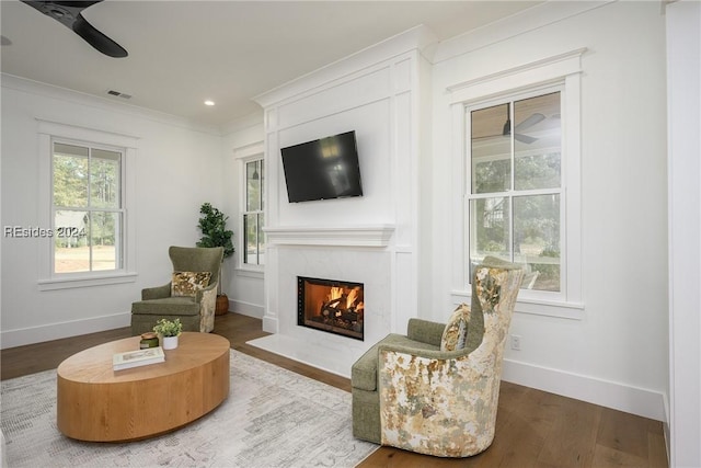 living room with hardwood / wood-style floors, ornamental molding, and ceiling fan