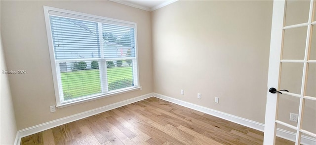 unfurnished room with crown molding, a healthy amount of sunlight, and light wood-type flooring