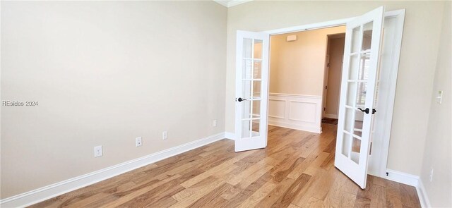 empty room with light hardwood / wood-style flooring and french doors