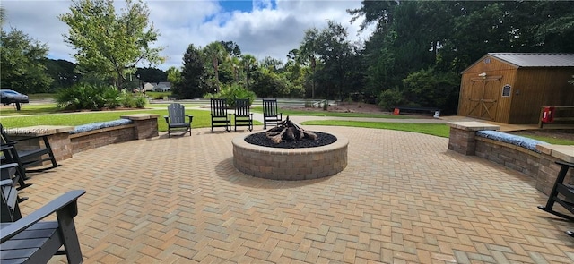 view of patio / terrace with a storage shed and an outdoor fire pit